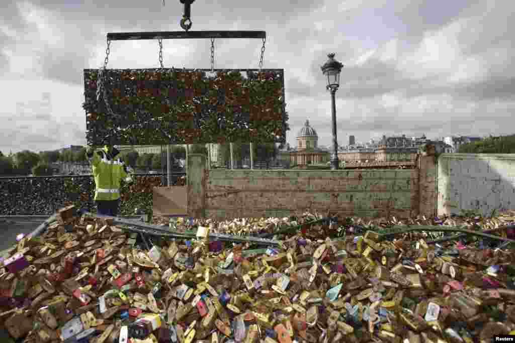 City municipal employees lower iron grills covered with "love locks" into a truck after they were removed from the Pont des Arts in Paris, France. The bridge is closed from June 1 - 8 to remove padlocks.