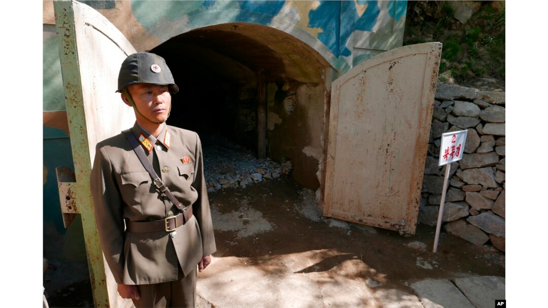 FILE - In this May 24, 2018 photo, a guard stands at the entrance of the north tunnel at North Korea's nuclear test site, which was blown up soon after this photo was made, in a display of dismantling the test site, at Punggye-ri, North Hamgyong Province, North Korea.
