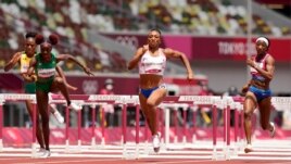 Jasmine Camacho-Quinn, of Puerto Rico, center, races to the line to win the gold in the women's 100-meters hurdles final at the 2020 Summer Olympics, Monday, A