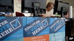 FILE - In this Oct. 8, 2012, file photo, a campaign volunteer inputs voter registration data into a computer at a campaign office for President Barack Obama in Miami.