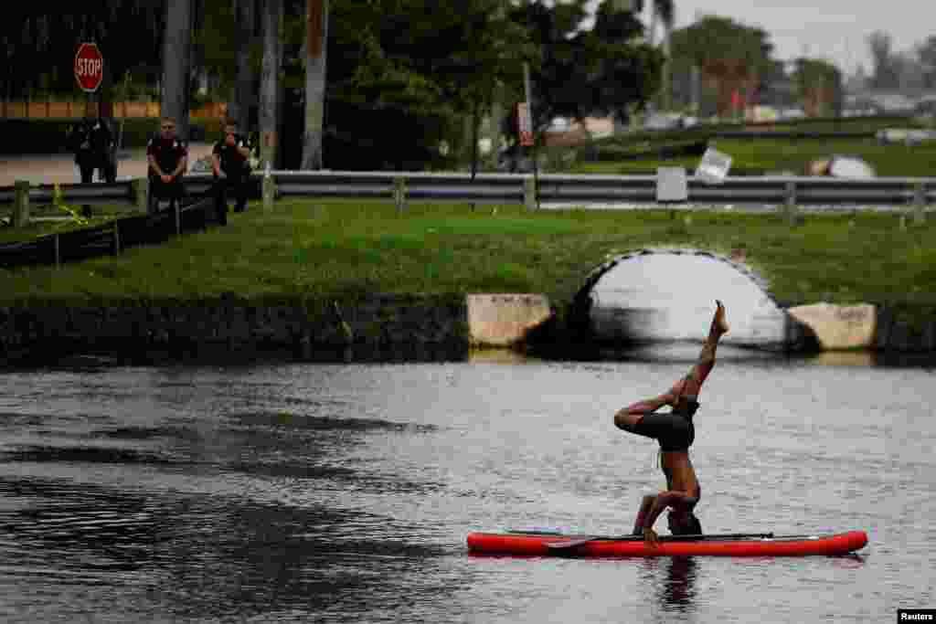 A man practices yoga on a paddle board outside Trump National Doral golf resort in Doral, Florida, June 6, 2020.