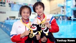 21일 대만 타이페이 대학에서 열린 2017 하계유니버시아드 여자 다이빙 10m 플랫폼 싱크로에서 금메달을 획득한 북한의 김국향 선수(왼쪽)와 김운향 선수가 기념 촬영을 하고 있다.