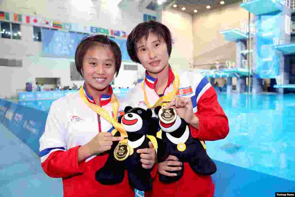 대만 타이페이 대학에서 열린 2017 하계유니버시아드 여자 다이빙 10m 플랫폼 싱크로에서 금메달을 획득한 북한의 김국향 선수(왼쪽)와 김운향 선수가 메달을 들고 미소 짓고 있다.