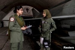 Cô Ayesha Farooq, 26 tuổi, (phải) nữ phi công máy bay chiến đấu duy nhất của Pakistan nói chuyện với kỹ sư hàng không Anam Hassan, 24 tuổi, tại căn cứ Mushaf ở Sargodha, phía bắc Pakistan, 7/6/2013.