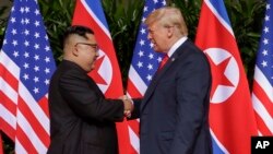 U.S. President Donald Trump shakes hands with North Korea leader Kim Jong Un at the Capella resort on Sentosa Island Tuesday, June 12, 2018 in Singapore. (AP Photo/Evan Vucci)