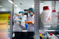 Petugas riset tengah meneliti perkembangan Covid-19 di laboratorium Teknologi Biologi Terapan di Beijing, China, 14 Mei 2020.