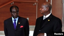 Zimbabwe President Robert Mugabe (L) stands next to his Ugandan counterpart Yoweri Museveni while marking the 50th anniversary of the establishment of the Organization of African Union (OAU) in Addis Ababa, May 25, 2013.
