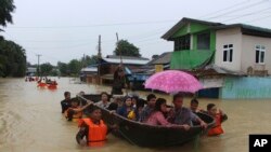 Regu Penyelamat Myanmar membawa warga dengan menggunakan perahu untuk menyusuri jalanan yang tergenang banjir di Bago, sekitar 80 kilometer timur laut Yangon, Myanmar, Minggu, 29 Juli 2018. (Foto: dok).