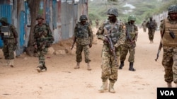 FILE - AMISOM soldiers and armored vehicles pass a woman riding a cart during a patrol at a village outside Mogadishu, Sept. 19, 2016. (Photo: J. Patinkin/VOA)