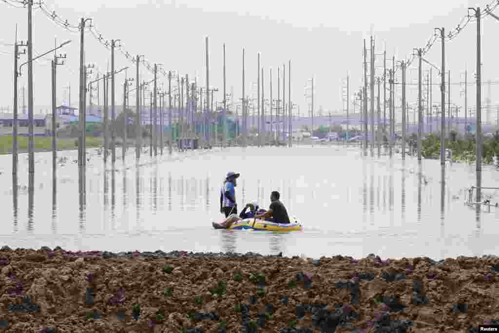 People are seen on a rubber boat along a flooded road at Amata Nakorn industrial Estate in Chonburi province, east of Bangkok, Thailand. Flooding at an industrial estate east of the capital has forced the closure of 2 foreign-owned factories producing electronic spare parts.