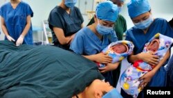중국 산시성 시안 시 병원 수술실에서 간호사들이 막 태어난 쌍둥이를 안고 있다. (자료사진)