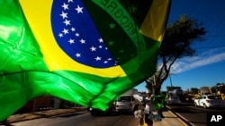 A street vendor sells representations of Brazil's national flags near the Arena Castelao in Fortaleza, Brazil, June 11, 2014. 