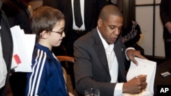 Entrepreneur and rapper Jay-Z signs a copy of his book, 'Decoded,' for a young fan at the New York Public Library.