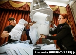 Anggota komisi pemilihan lokal mengosongkan kotak suara di tempat pemungutan suara setelah hari terakhir pemilihan parlemen tiga hari, di Moskow, pada 19 September 2021. (Foto: AFP)