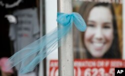 A ribbon for missing University of Iowa student Mollie Tibbetts hangs on a light post, Aug. 21, 2018, in Brooklyn, Iowa.