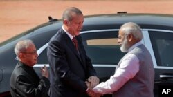 Presiden Turki Recep Tayyip Erdogan (tengah) didampingi Presiden India Pranab Mukherjee (kiri) berjabat tangan dengan PM India Narendra Modi (kanan) setibanya di Istana Presiden India di New Delhi, 1 Mei 2017. (AP Photo/Manish Swarup).
