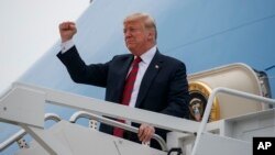 FILE - President Donald Trump gestures as he arrives at Springfield-Branson National Airport before attending a campaign rally in Springfield, Missouri, Sept. 21, 2018.