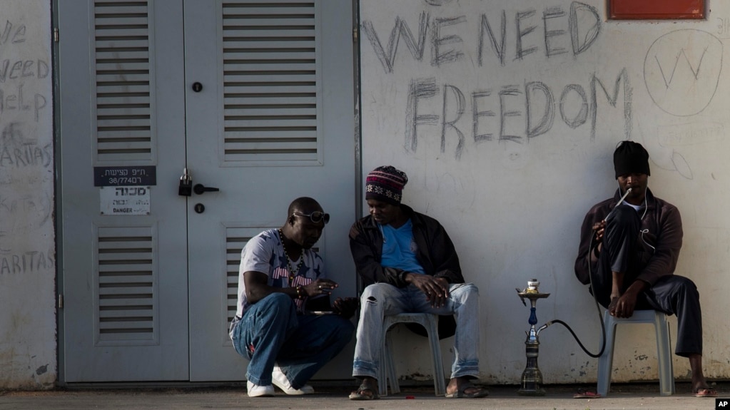 FILE - African migrants sit outside Holot detention center in the Negev Desert, southern Israel, April 21, 2015.