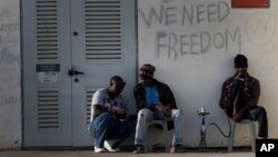 FILE - African migrants sit outside Holot detention center in the Negev Desert, southern Israel, April 21, 2015.