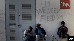 FILE - African migrants sit outside Holot detention center in the Negev Desert, southern Israel, April 21, 2015.