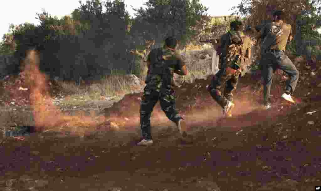 Free Syrian Army soldiers aim their weapons in Idlib, northern Syria, July 13, 2012.