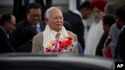 Malaysian Prime Minister Najib Razak holds a bouquet of flowers presented to him upon arrival in New Delhi, India, March 31, 2017.