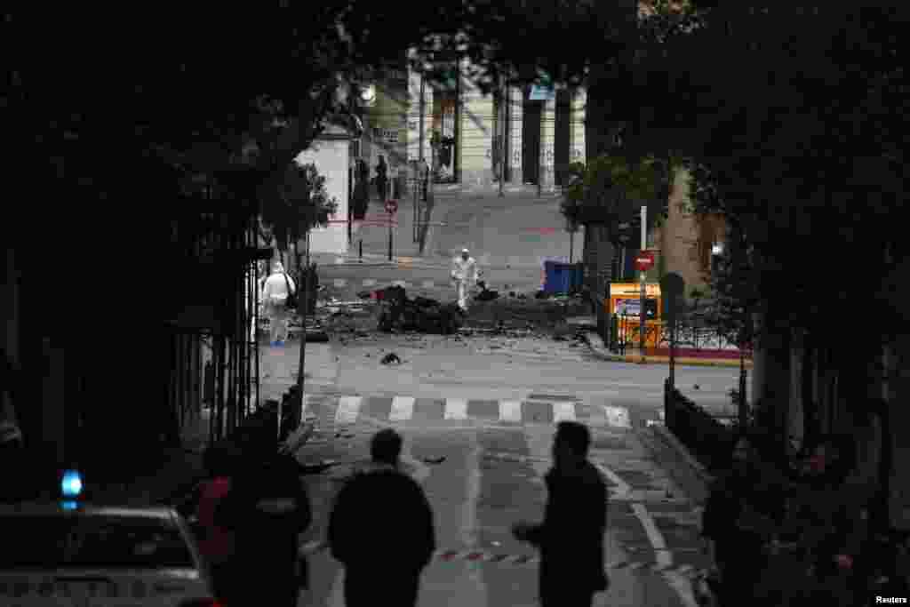 Forensic experts search for evidence on a street where a car bomb went off in Athens, April 10, 2014.