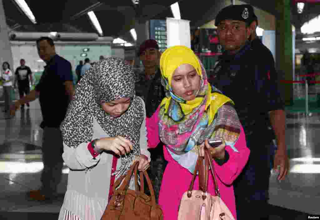 Family members of those onboard the missing Malaysia Airlines flight walk into the waiting area at Kuala Lumpur International Airport in Sepang.