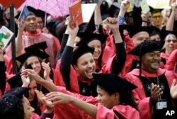 FILE – Students celebrate after graduating from the Harvard School of Education during Harvard University commencement exercises in Cambridge, Mass., May 25, 2017.