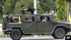 A military vehicle with a mounted grenade launcher makes its way during clashes between Thai and Cambodia in Surin province, northeastern Thailand, Thursday, April 28, 2011. Thai and Cambodian military commanders agreed to a cease-fire Thursday after sev