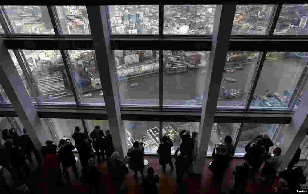 Visitors look out from windows in The View gallery at the Shard, western Europe&#39;s tallest building, in London. The public viewing deck, accessible by high speed elevators on the 309-meter (1,013 feet) building, opened to the public Friday.