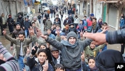 Anti-Syrian regime protesters chant slogans and flash the victory sign as they march during a demonstration at the mountain resort town near the Lebanese border, Zabadani, Syria, January 17, 2012.