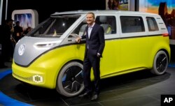 Dr. Herbert Diess, chairman of the VW brand, poses with the I.D. Buzz all-electric concept van at the North American International Auto Show, Jan. 9, 2017, in Detroit.