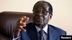 Zimbabwe's President Robert Mugabe gestures while addressing a meeting of his ZANU-PF party's supreme decision making body in Harare, August 7, 2013. 