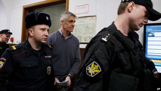Founder of the Baring Vostok investment fund Michael Calvey, center, is escorted to the courtroom in Moscow, Feb. 15, 2019. A veteran U.S. investment fund manager has been detained in Moscow and faces fraud charges.