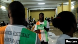 FILE - A polling official counts ballots at a polling station during the referendum for a new constitution, in Abidjan, Ivory Coast, Oct. 30, 2016.