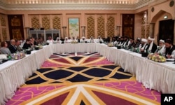 This photo released by Qatar's Ministry of Foreign Affairs shows Qatari, U.S. and Taliban officials conferring in an undisclosed place in Doha, Feb. 25, 2019.