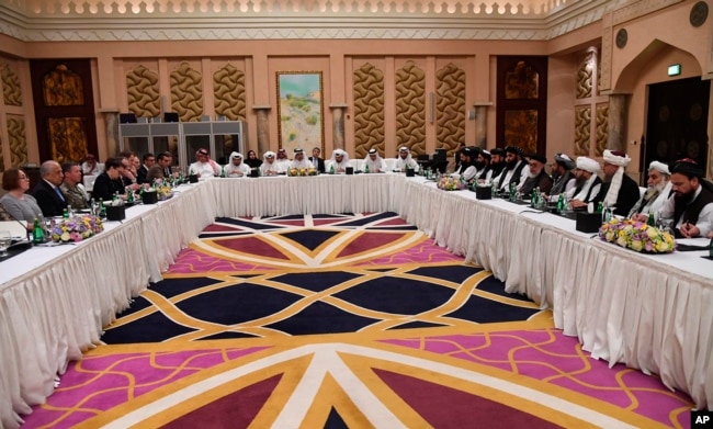 FILE - This photo released by Qatar's Ministry of Foreign Affairs shows Qatari, U.S. and Taliban officials conferring in an undisclosed place in Doha, Feb. 25, 2019, ahead of the latest round of talks with the insurgents aimed at ending the Afghan war.