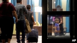 FILE - Immigrants seeking asylum who had been recently reunited with children arrive at a hotel, in San Antonio, July 23, 2018.