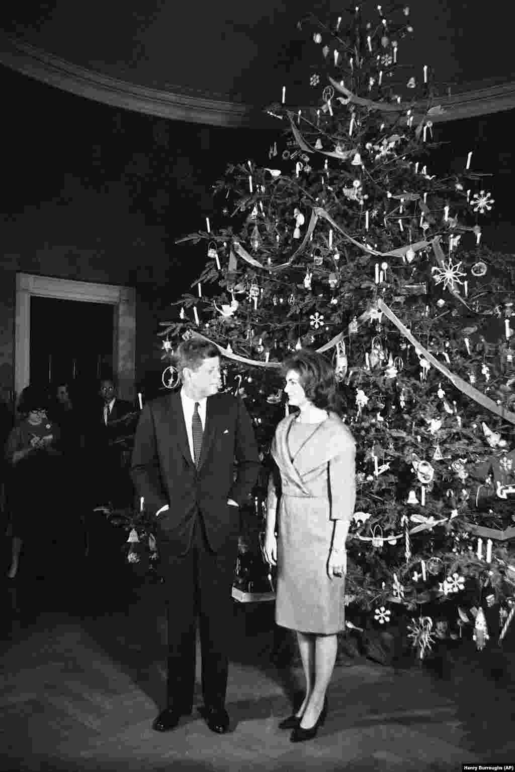 1961 рік. Президент Джон Кеннеді та Жаклін Кеннеді перед ялинкою у Блакитній кімнаті Білого дому у Вашингтоні. Фото зроблене під час різдвяної вечірки для співробітників Білого дому та їх сімей.&nbsp;
