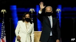 Presiden terpilih Joe Biden, kanan, di atas panggung bersama Wakil Presiden terpilih Kamala Harris, kiri, Sabtu, 7 November 2020, di Wilmington, Delaware. (Foto: AP)