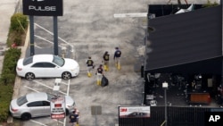 FBI officials approach the Pulse night club, the site of a mass shooting days earlier, in Orlando, Florida, June 15, 2016.