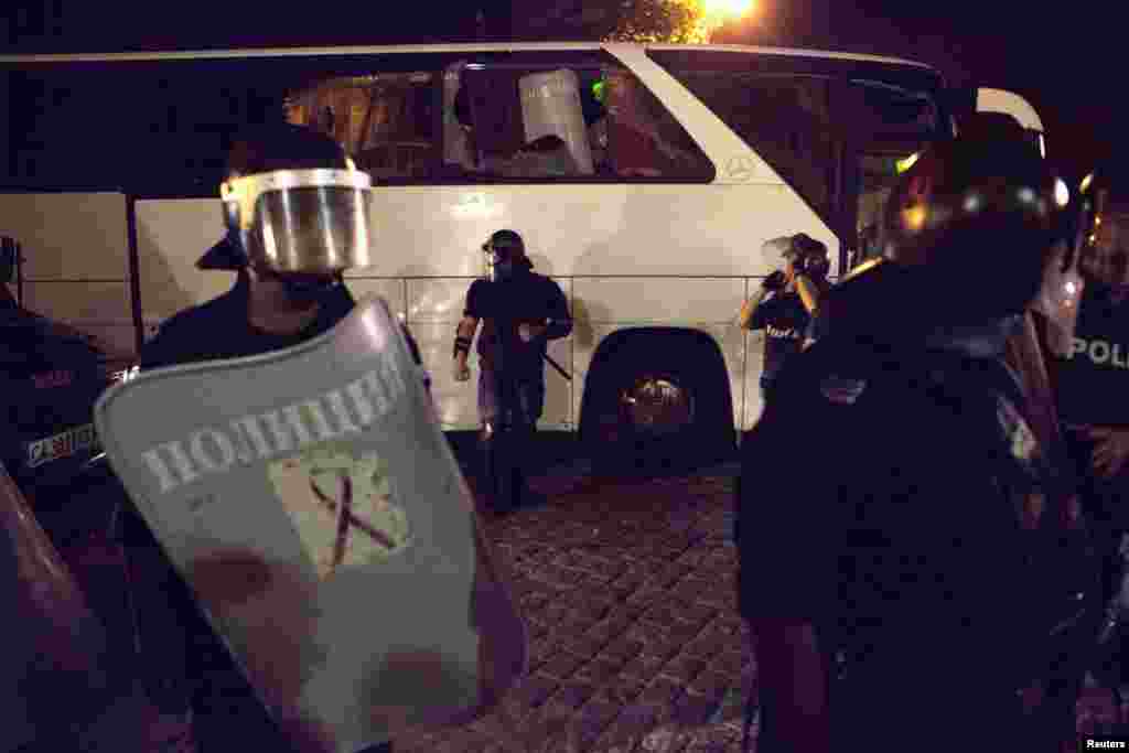 Police guard a bus for members of parliament, Sofia, Bulgaria, July 23, 2013. 