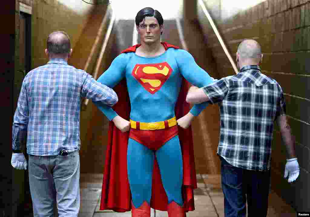 Employees carry the Superman costume worn by Christopher Reeve from the 1978 and 1980 films which goes on display at the IMAX before being auctioned later this month in London, Britain.