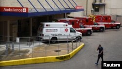 Seorang petugas medis berjalan melintas jajaran ambulans yang terparkir di luar Rumah Sakit Houston Methodist di tengah pandemi virus corona, di Houston, Texas, 22 Juni 2020. (Foto: Reuters)