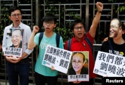 Student leader Joshua Wong, second from left, chants slogans during a protest demanding the release of Chinese Nobel rights activist Liu Xiaobo outside China's Liaison Office in Hong Kong, June 27, 2017.