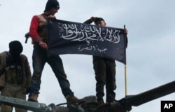 FILE - Rebels from al-Qaida-affiliated Jabhat al-Nusra wave their brigade flag as they step on the top of a Syrian air force helicopter at Taftanaz air base, Jan. 11, 2013.