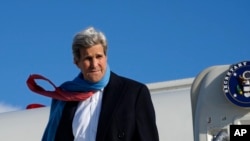 U.S. Secretary of State John Kerry reacts to the blustery weather on arrival in Munich, Germany, Jan. 10, 2015. 