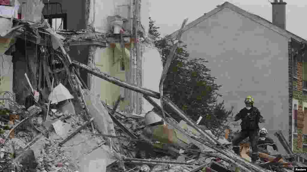 French firefighters search the rubble of a collapsed building, in which a child and elderly woman were killed, in Rosny-Sous-Bois, near Paris, Aug. 31, 2014. 