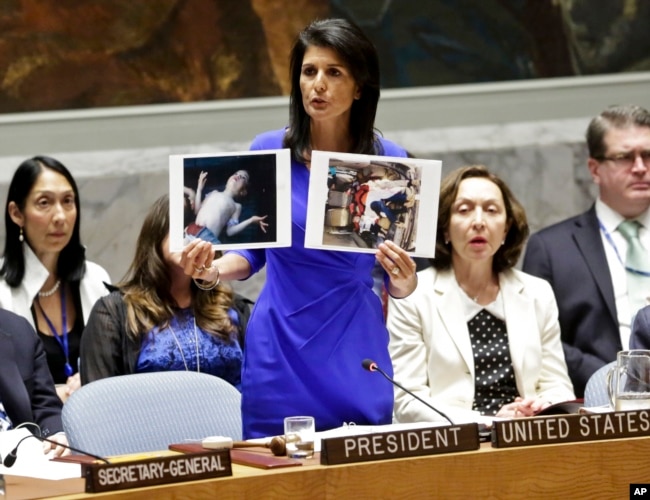 U.S. Ambassador to the United Nations Nikki Haley shows pictures of Syrian victims of chemical attacks as she addresses a meeting of the Security Council on Syria at U.N. headquarters, in New York, April 5, 2017.